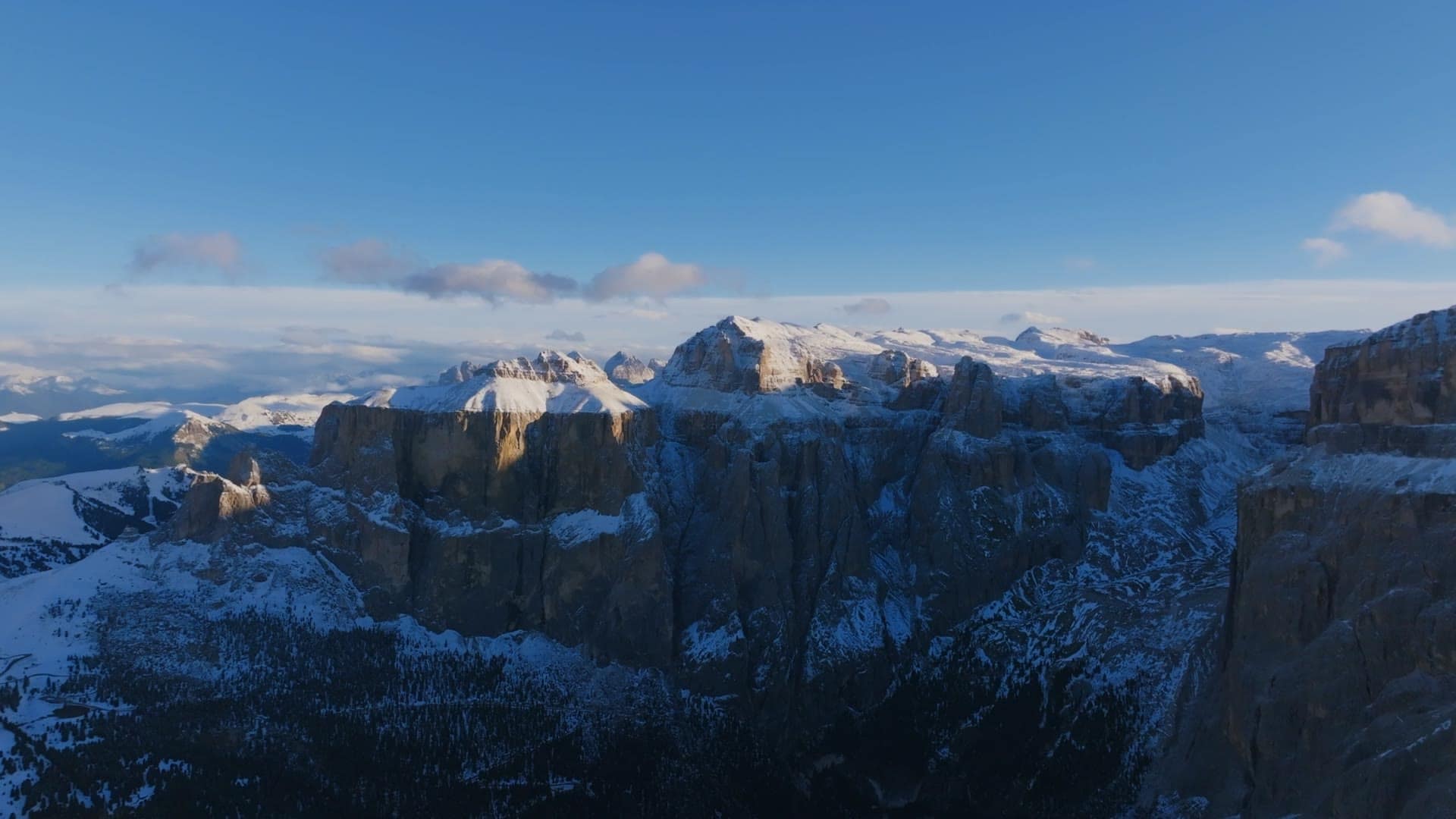 Snow-capped Dolomite peaks catching first light above a deep valley